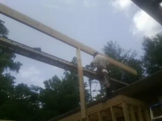 Carpenter setting a ridge beam over a new addition frame — Ice Dam Removal by Roofing Brothers in Uncasville