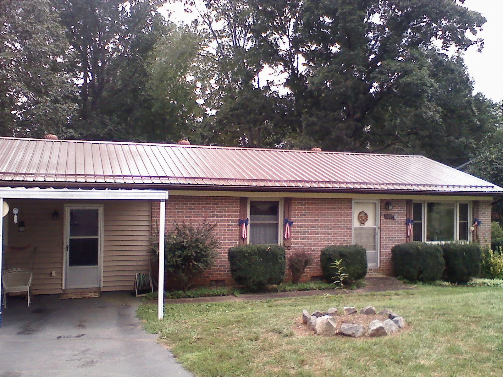 Bronze metal roof and carport on a brick ranch home — Roof Repair work by our crew in Uncasville